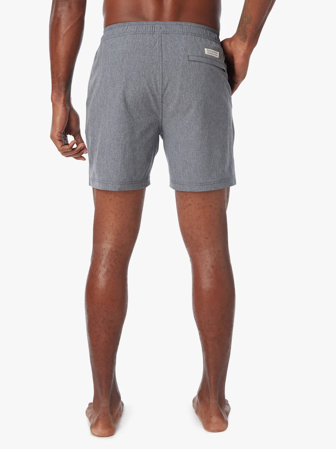 Man wearing a grey one shorts in 6 inch inseam with a drawstring on a white background, showing the back view.