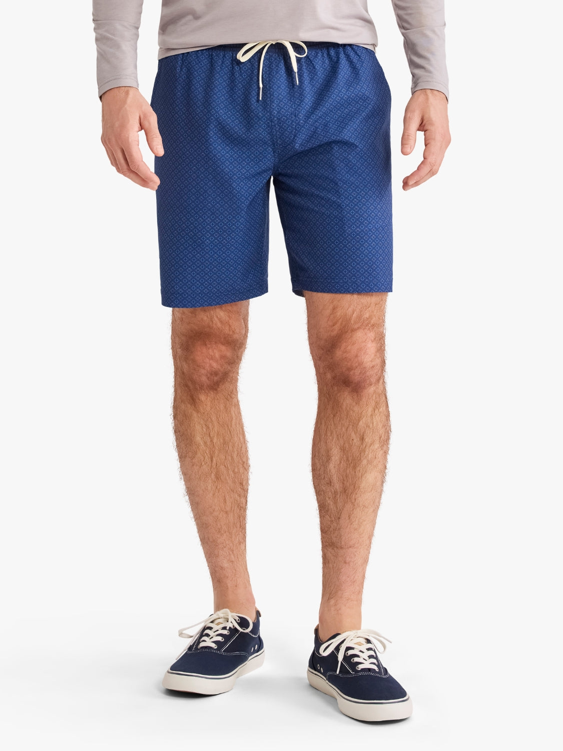 Person wearing blue patterned shorts on a white background