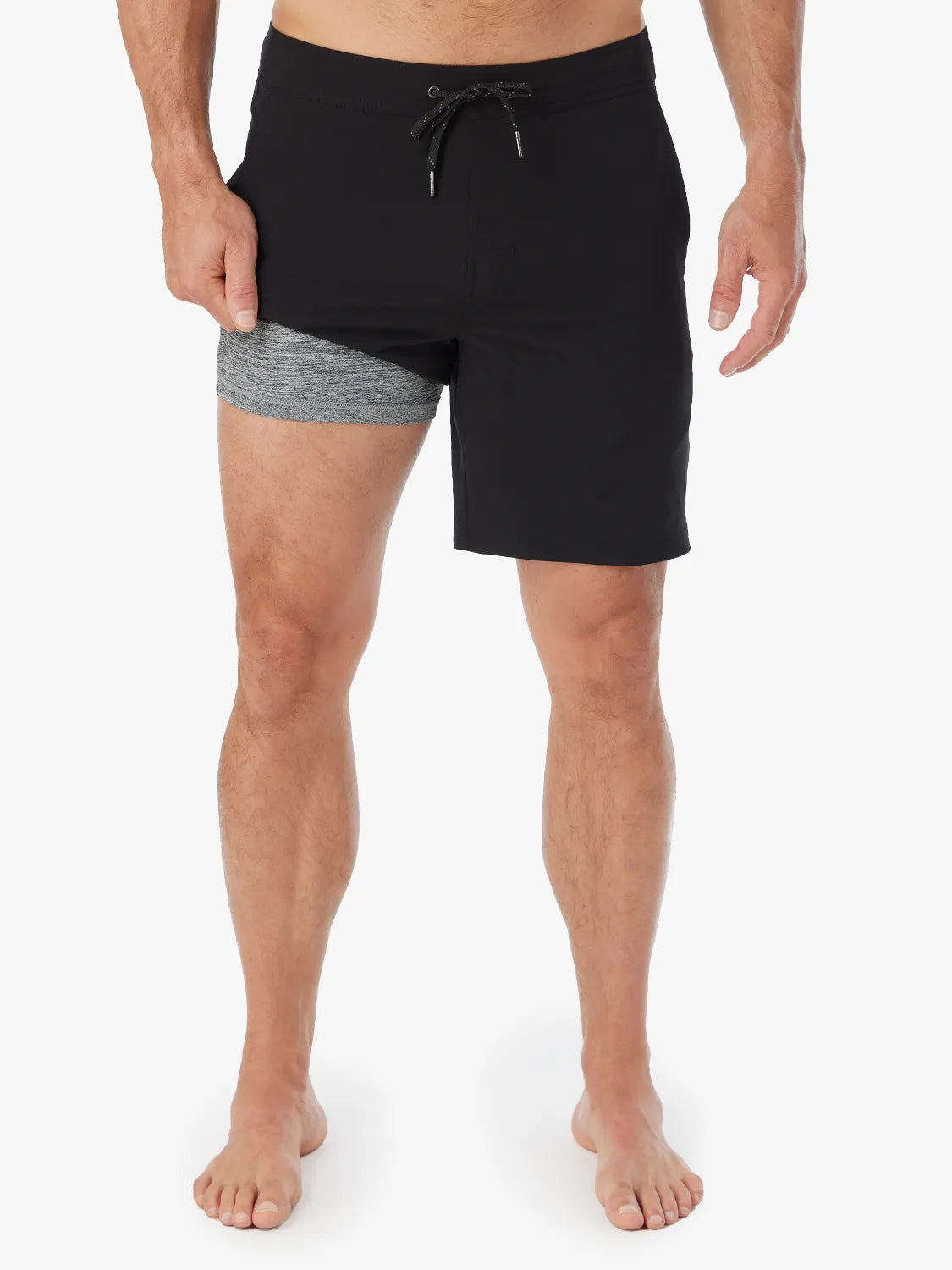 Person wearing a pair of black Ozone shorts with drawstring on a white background, showing the liner. 