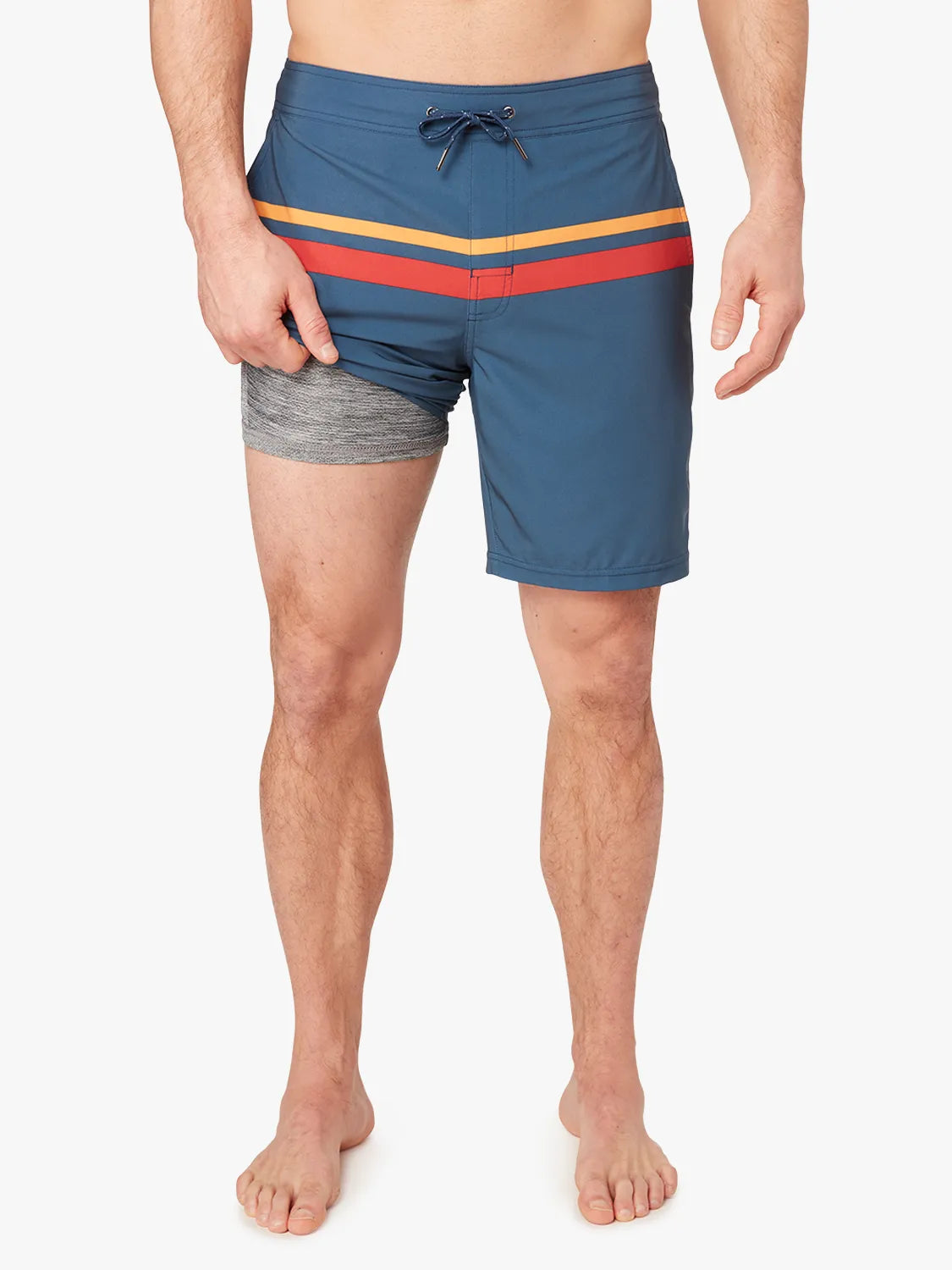 Person wearing a pair of ozone blue board shorts with red and yellow stripes on the upper part and a drawstring at the waist on a white background. Showing the liner underneath. 