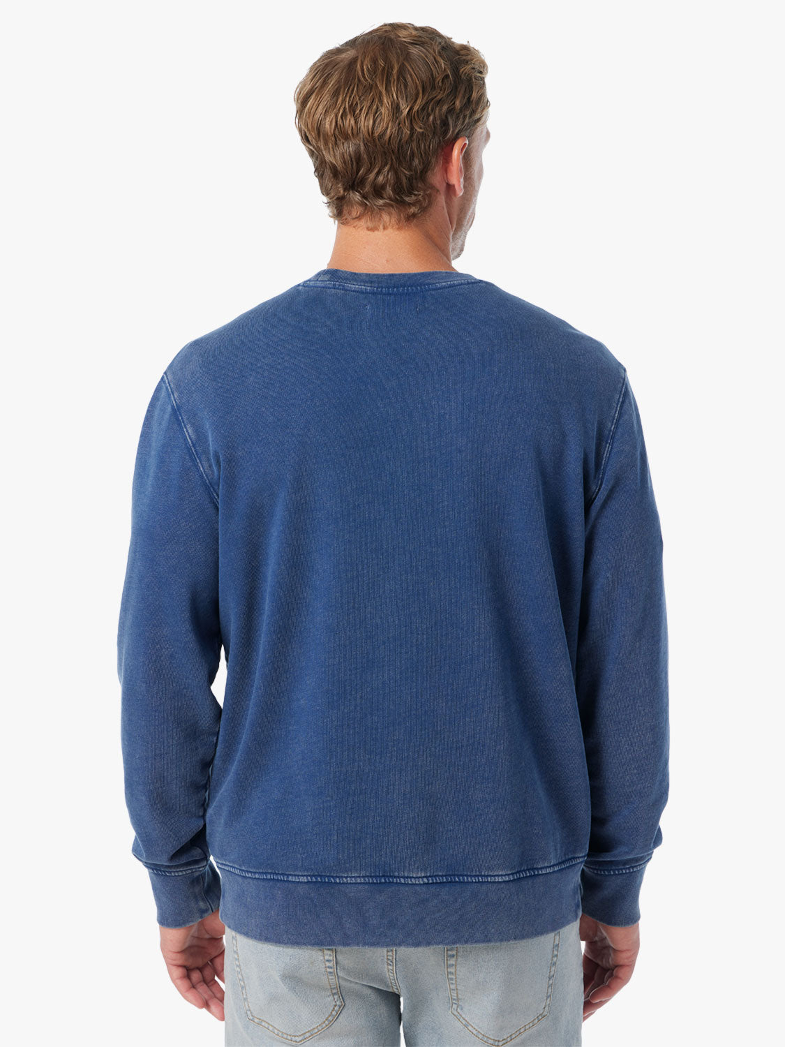 Man wearing navy blue saltaire sweatshirt on a white background, showing the back view of sweatshirt. 
