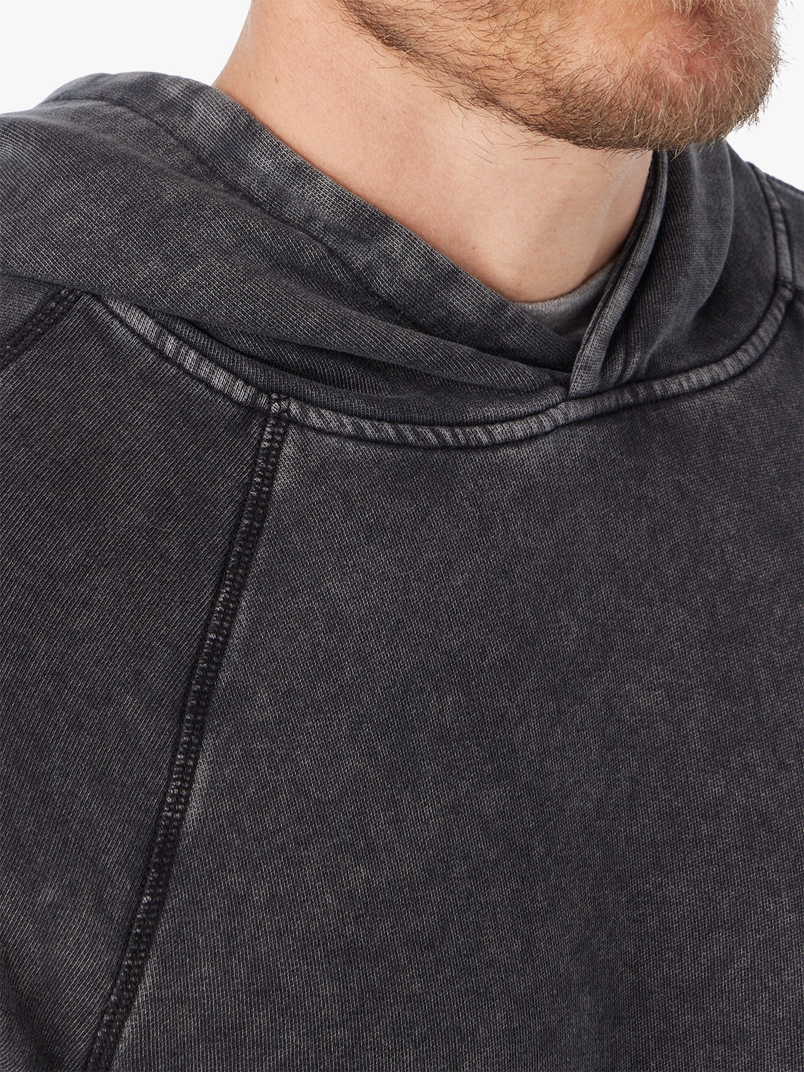 Close-up of black saltaire hoodie, showing the neckline & stitching detail.