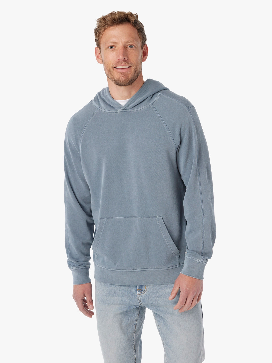 Man wearing the maritime saltaire hoodie on a white background, paired with jeans and a white t-shirt underneath hoodie.