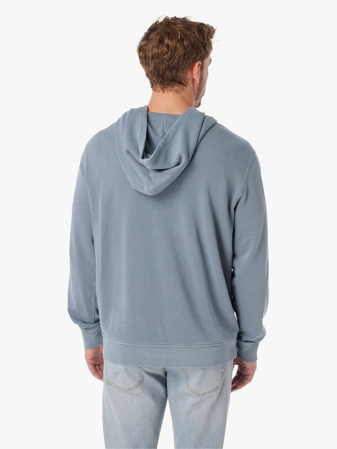 Man wearing saltaire hoodie in maritime color, showing the back view. Paired with jeans.