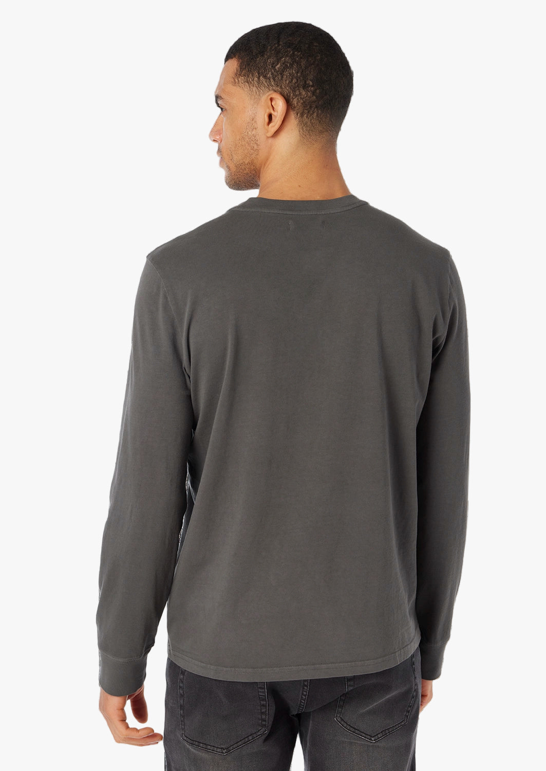 Man wearing a black long-sleeve shirt on a white background paired with black driftwood denim 