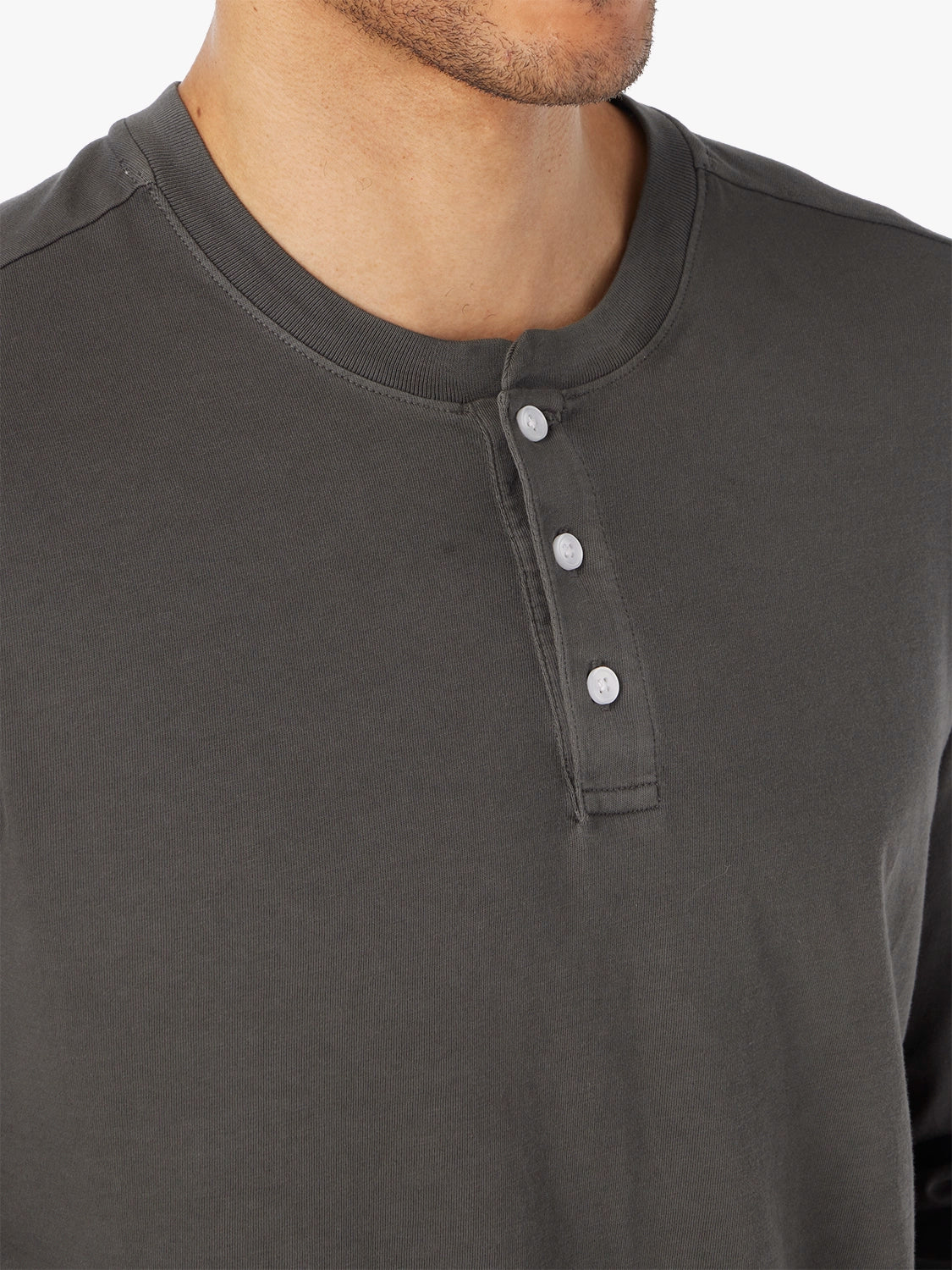 Close-up of a black long-sleeve shirt with white button details.