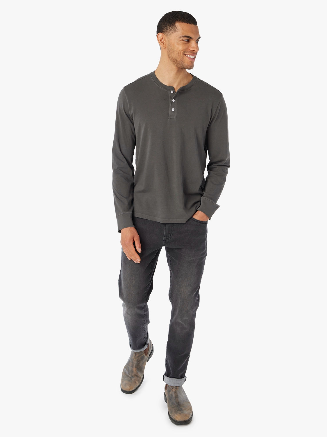 Man wearing a black saltaire long-sleeve henley shirt and black driftwood denim  jeans on a white background