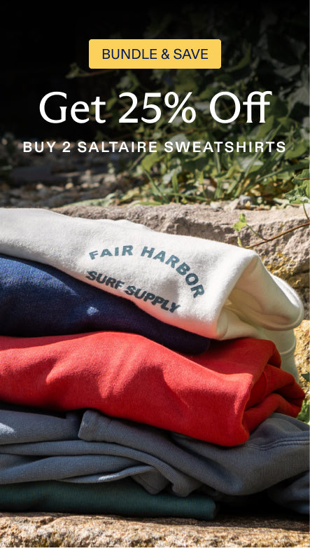 Stack of Saltaire sweatshirts with promotional text overlay on a natural background