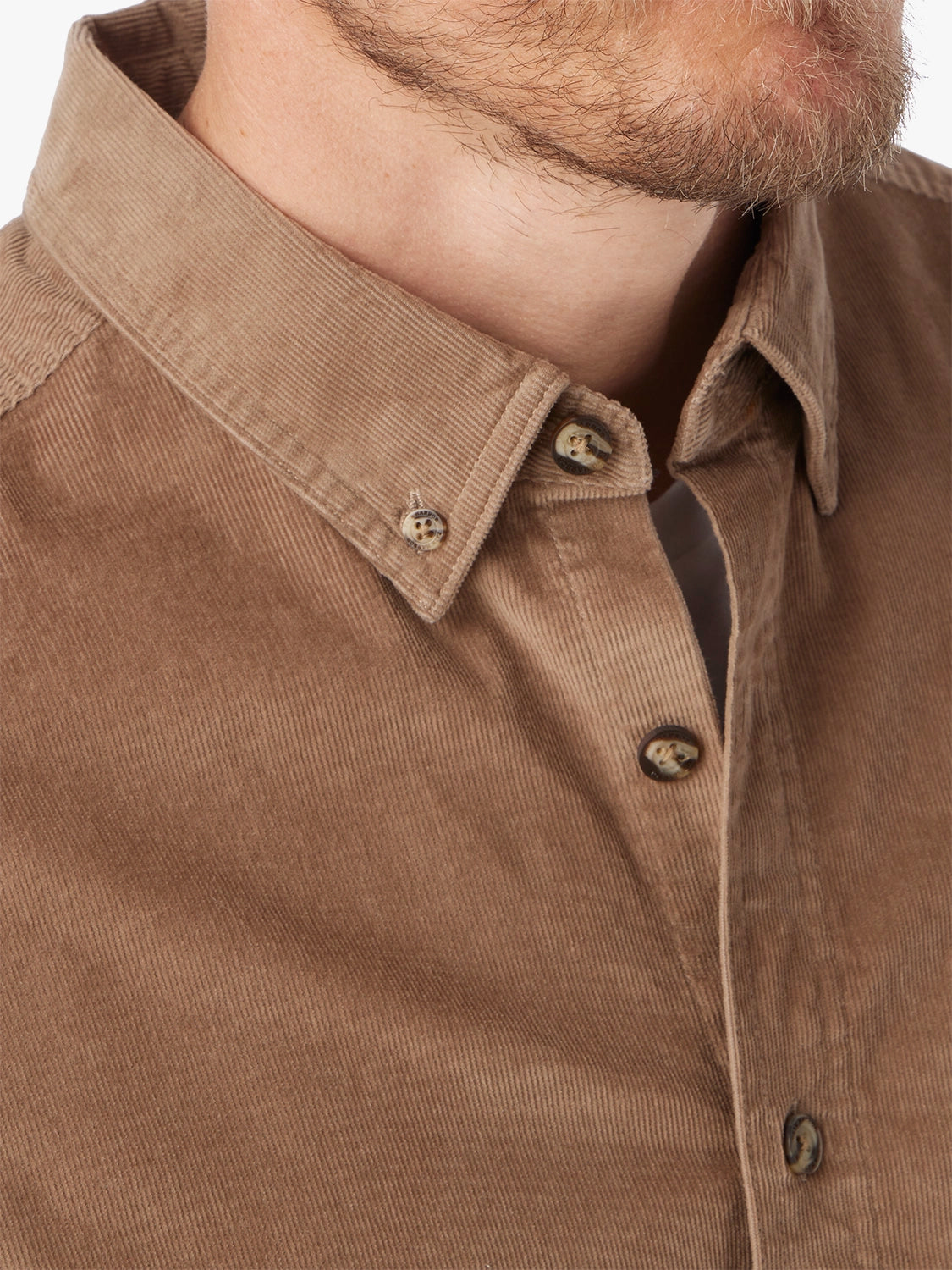 Close-up of a brown corduroy shirt with collar and buttons.