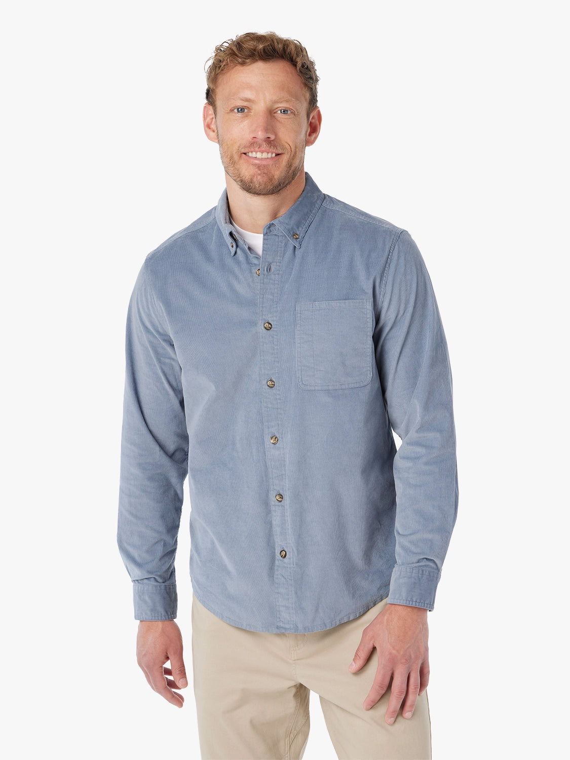 Man wearing blue corduroy button-up shirt on a white background, paired with khaki horizon pants. 
