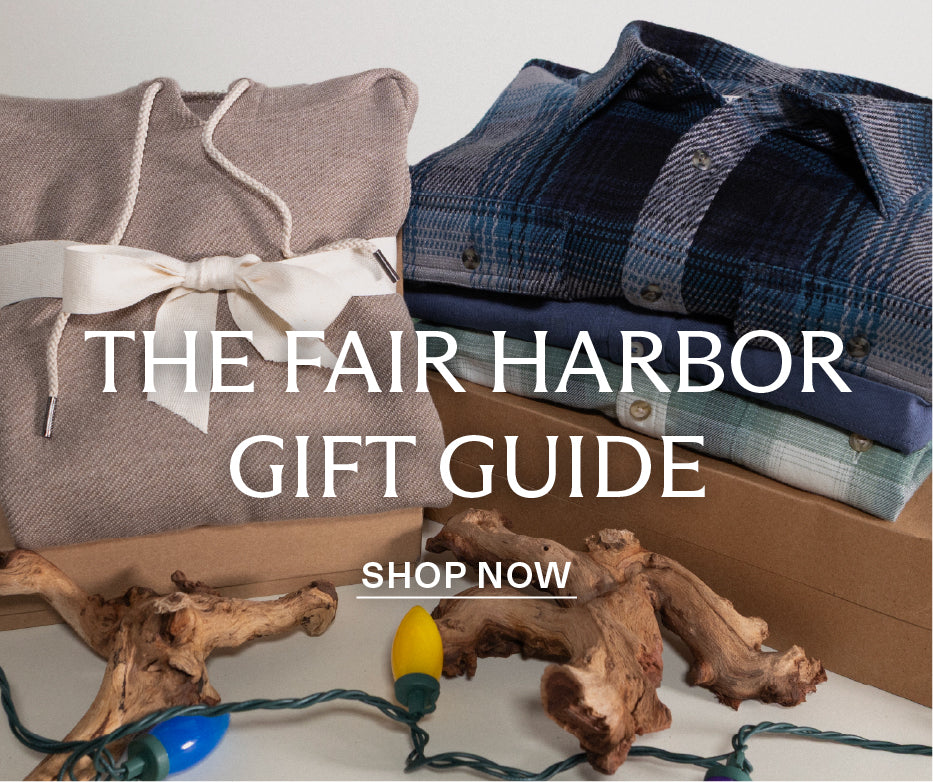 Gift guide with folded clothes, a present boxes, and decorative Christmas lights on a neutral background. With text 
