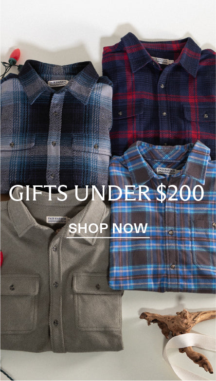 Four plaid shirts in blue, red, and green, black folded on a white surface with text 'Gifts Under $200' and 'Shop Now'. Promoting gift options under $200